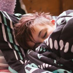 Teenager asleep and wrapped in a blanket