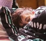 Teenager asleep and wrapped in a blanket