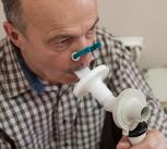 Man testing breathing function by spirometry - stock photo
